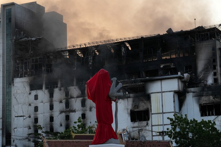 Smoke rises from part of the Grand Diamond City hotel-casino, as Thai and Cambodian rescuers struggle to extricate dozens of people feared trapped after a fire broke, killing at least 10 and injuring dozens in Poipet near Thailand border, Cambodia