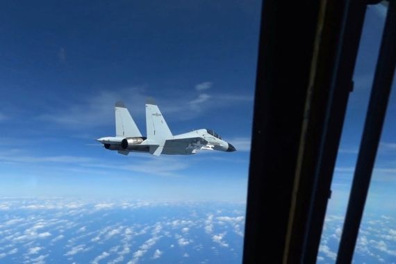 A still image from a video shot on December 21, 2022, shows a Chinese Navy J-11 fighter jet flying close to a US Air Force RC-135 aircraft in international airspace over the South China Sea.