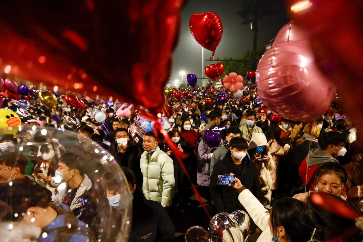 People hold balloons as they gather to celebrate New Year's Eve in Wuhan.