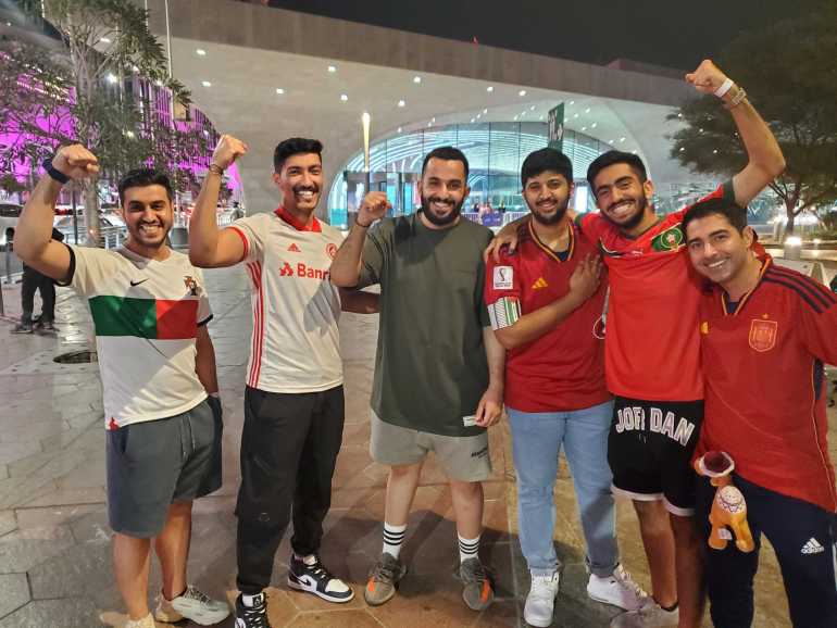 Atlas Lions fans pumping their fists in the air in celebration of Morocco's victory against Spain.