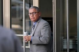 Ex-prison warden Ray Garcia exits courthouse, a cup in hand