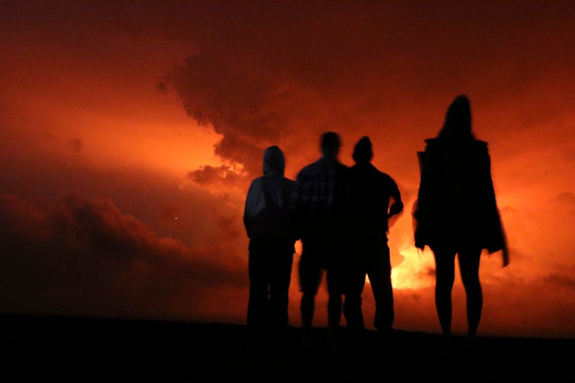 People watch the glow from lava erupting