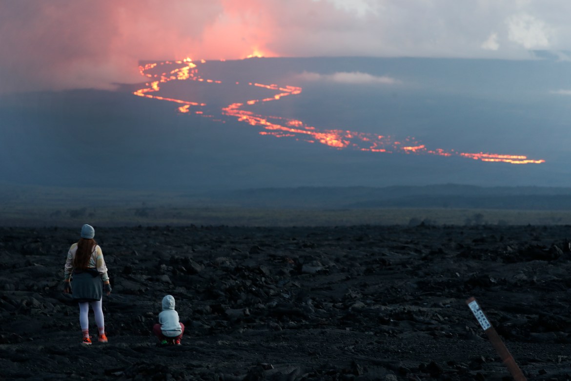 Spectators watch the lava flow down the mountain