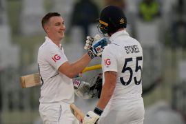 England's Harry Brook, left, is congratulated by teammate Ben Stokes after scoring century during the first day of the first test cricket match between Pakistan and England, in Rawalpindi, Pakistan, Dec. 1, 2022. (AP Photo/Anjum Naveed)