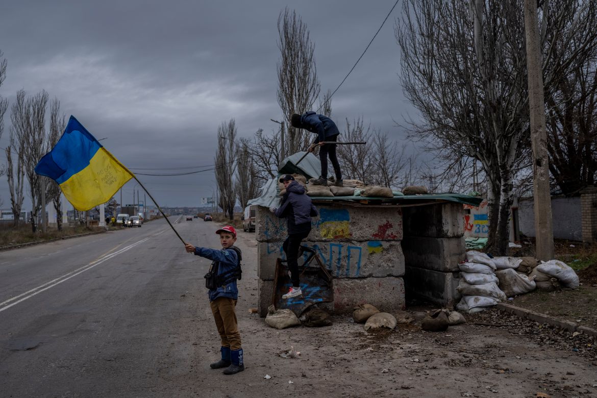 Ukrainian children play at an abandoned checkpoint in Kherson, southern Ukraine, Wednesday, Nov. 23, 2022. (AP Photo/Bernat Armangue)
