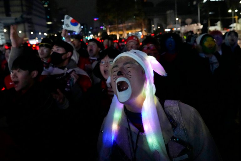 A South Korean soccer fan reacts as he watches a live broadcasting of the World Cup 2022 round of 16 soccer match between South Korea and Brazil in Qatar, at a public viewing venue in Seoul, South Korea, Tuesday, Dec. 6, 2022. (AP Photo/Ahn Young-joon)