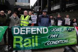 Mick Lynch, general secretary of the Rail, Maritime and Transport union (RMT), center, joins the members of rail workers during a strike outside Euston station in London, Tuesday, Dec. 13, 2022. (AP Photo/Kin Cheung)