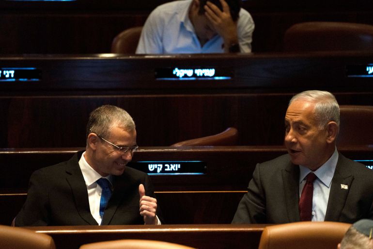 Israeli Prime Minister designate Benjamin Netanyahu, right, and Yariv Levin, left, wait as as lawmakers vote on Levin as Speaker of the Knesset,