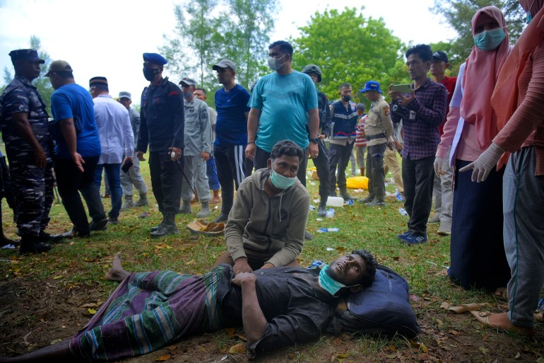 An ethnic Rohingya man lies on the ground as he waits for medical treatment