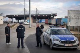 Kosovo police officers inform travelers of the closed Merdare border crossing between Kosovo and Serbia
