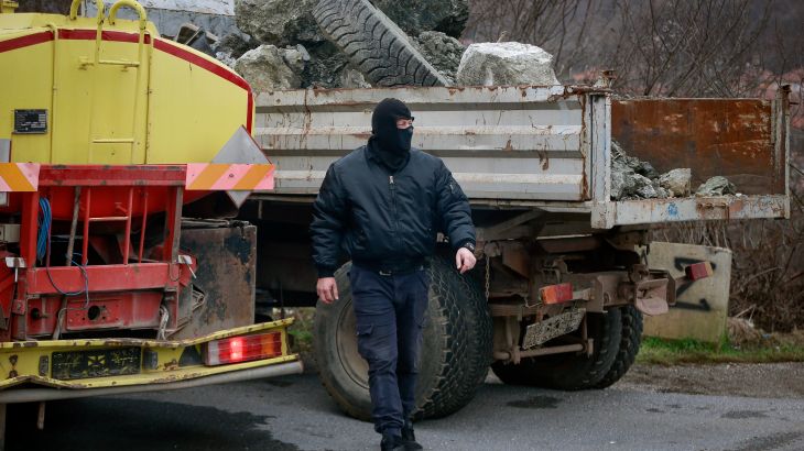 A Masked Serb walks as they remove trucks from Rudare barricade near the northern, Serb-dominated part of ethnically divided town of Mitrovica, Kosovo