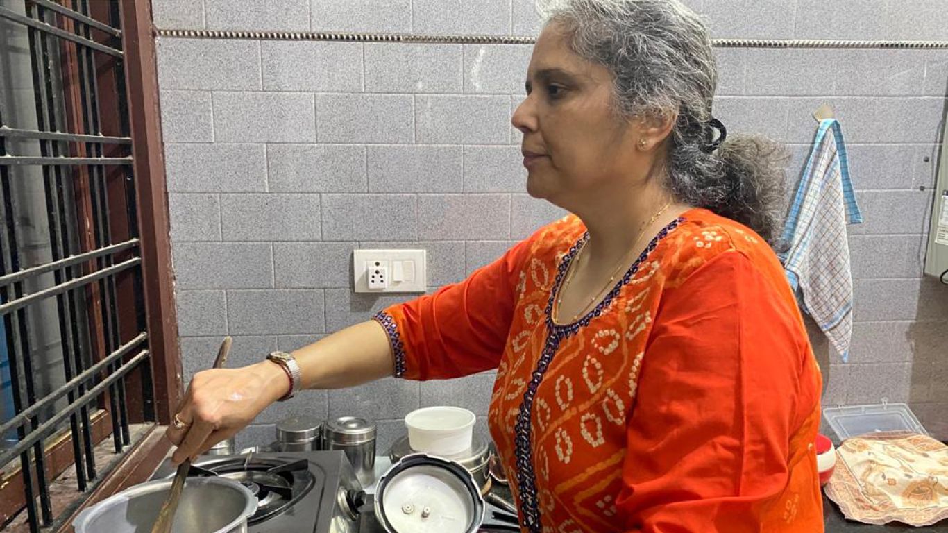Payal at the stove, cooking by feel because she lost her eyesight