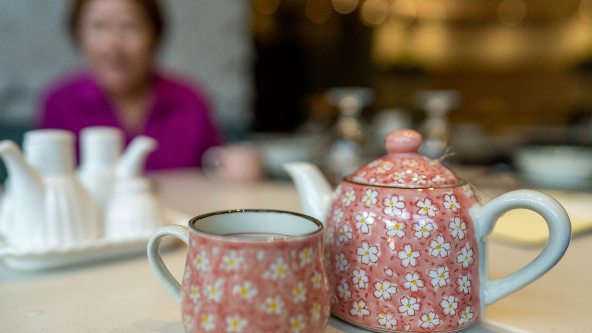 Pink teacup and teapot in the foreground, in the background is Ma Zhong Yan, slightly blurry