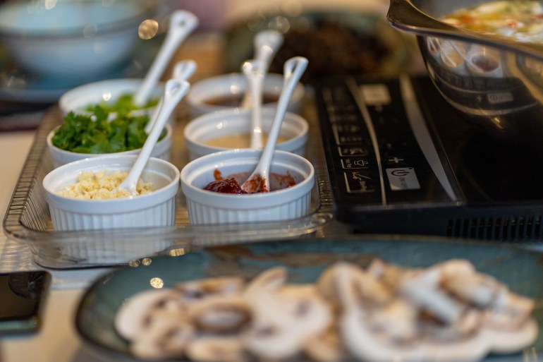 closeup of a tray of condiments so diners can mix their own dipping sauce for hotpot