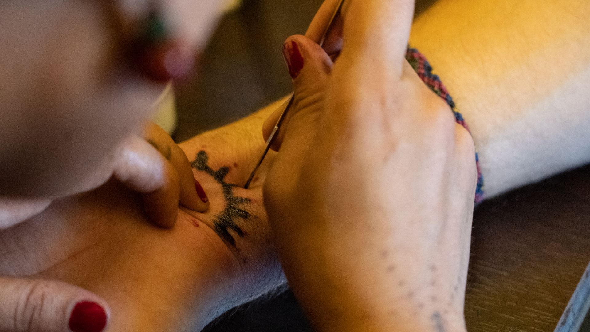 A woman giving someone a deq tattoo