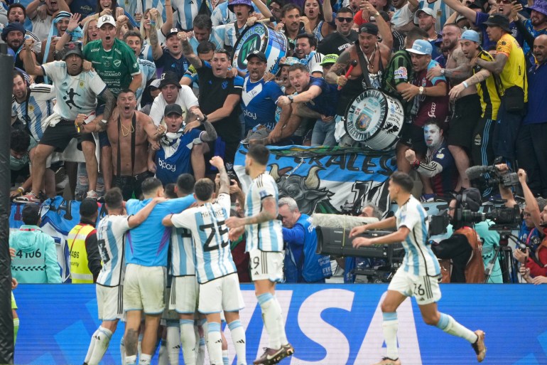 Argentina fans shout in celebration towards their players after Argentina scored their third goal of the match.