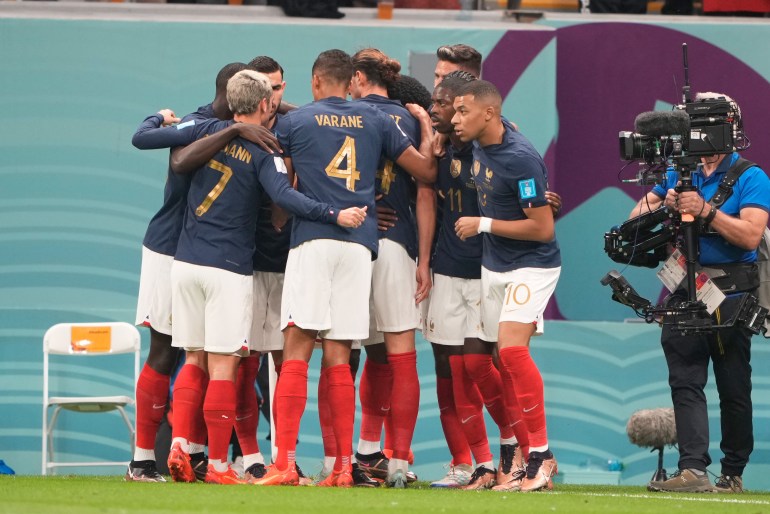 Players from France huddle in celebration after scoring.