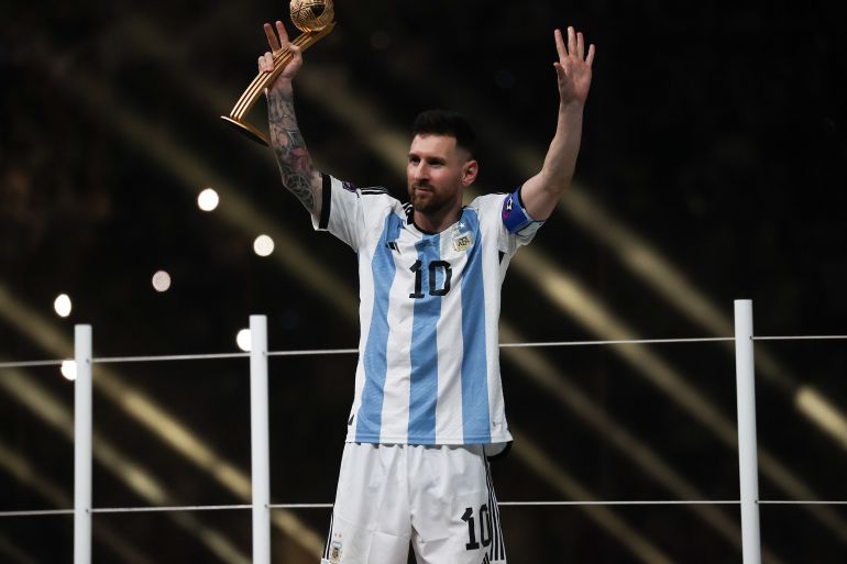 Lionel Messi celebrates Argentina's win, trophy in hand.