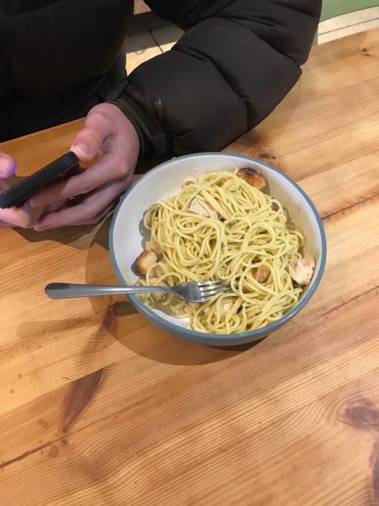 A person eating a bowl of pasta