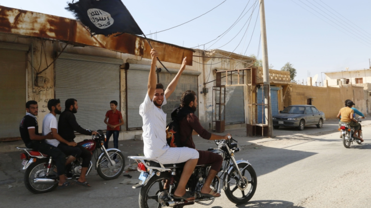 A man on a bike raises the ISLI (ISIS) flag.