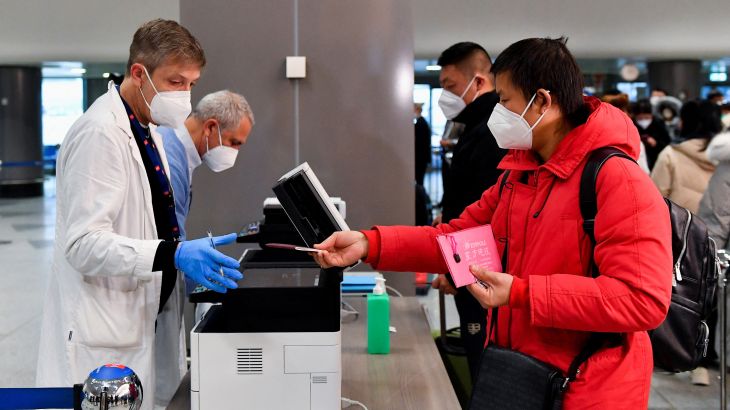 A passenger gives his passport to a worker, after Italy has ordered coronavirus disease (COVID-19) antigen swabs and virus sequencing for all travellers coming from China