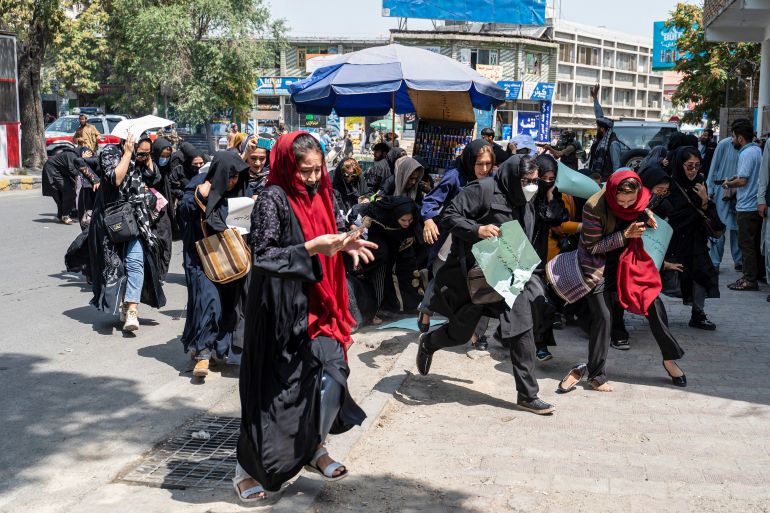 Taliban fighters fire into the air to disperse Afghan women protesters in Kabul on August 13, 2022.