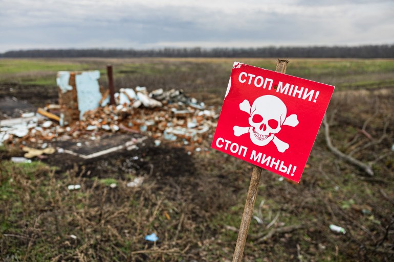 A photograph shows a warning sign which reads as "Stop Mines" written in both Ukrainian and Russian languages in the Donetsk region, eastern Ukraine, on January 2, 2023.