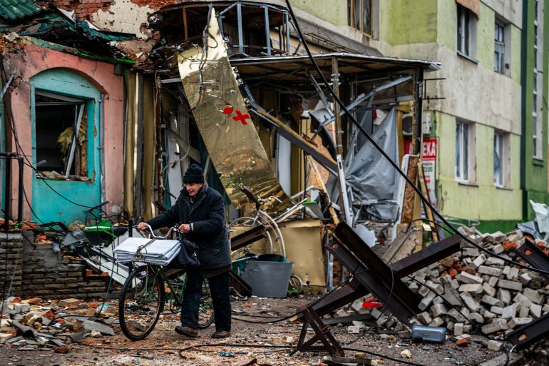 A local resident pushes his bicycle past "hedgehog" tank traps and rubble, down a street in Bakhmut, Donetsk region, on January 6, 2023, amid the Russian invasion of Ukraine. - Russia and Ukraine have both suffered heavy casualties in the fight for Bakhmut, and most of the city's pre-war population of 70,000 have left for safer territory, leaving behind cratered roads and buildings reduced to rubble and twisted metal. (Photo by Dimitar DILKOFF / AFP)