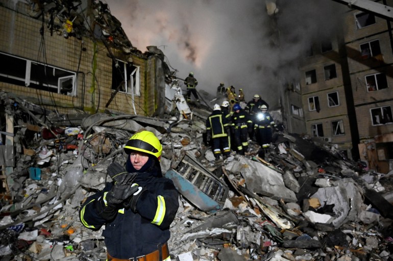 Rescuers work on a residential building destroyed after a missile strike, in Dnipro on January 15, 2023, amid the Russian invasion of Ukraine.