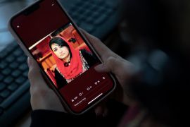 A woman looks at a picture of former Afghan lawmaker Mursal Nabizada on her mobile phone, who was shot dead by gunmen last night at her house in Kabul on January 15, 2023. - Mursal Nabizada had been a member of parliament in the previous Western-backed regime who had turned down the opportunity to flee Afghanistan when the Taliban seized power in August 2021. "Nabizada, along with one of her bodyguards, was shot dead at her house," Kabul police spokesman Khalid Zadran said on January 15. (Photo by Wakil KOHSAR / AFP)