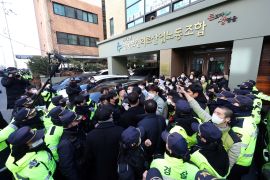 Labour group members struggle with police in front of the headquarters of the Korean Health and Medical Workers' Union (KHMU) of the Korean Confederation of Trade Unions (KCTU) in Seoul on January 18, 2023, as South Korea's spy agency and police raid the country's main labour union group over alleged pro-Pyongyang activities. (Photo by YONHAP / AFP) / - South Korea OUT / REPUBLIC OF KOREA OUT NO ARCHIVES RESTRICTED TO SUBSCRIPTION USE