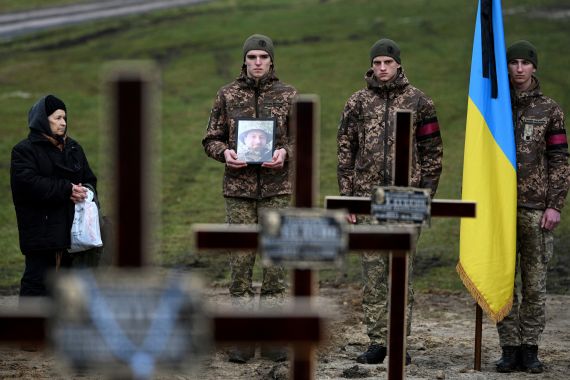 Ukrainian soldiers attend a funeral ceremony for their comrades