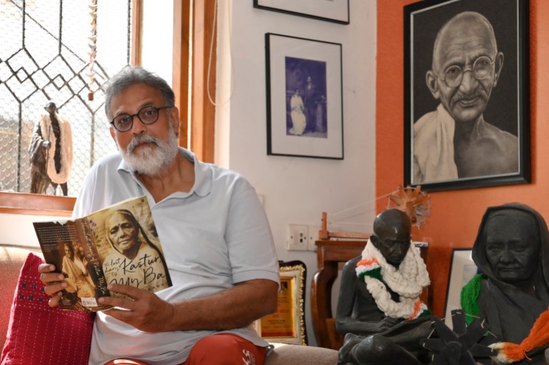 In this picture taken on January 25, 2023, Indian author Tushar Gandhi, the great grandson of Mahatma Gandhi, reads a book during an interview at his home in Mumbai