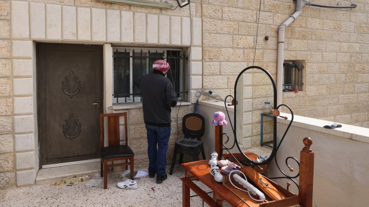 A relative of a Palestinian gunman inspects the barricade put up by Israeli soldiers at the Alqam family home