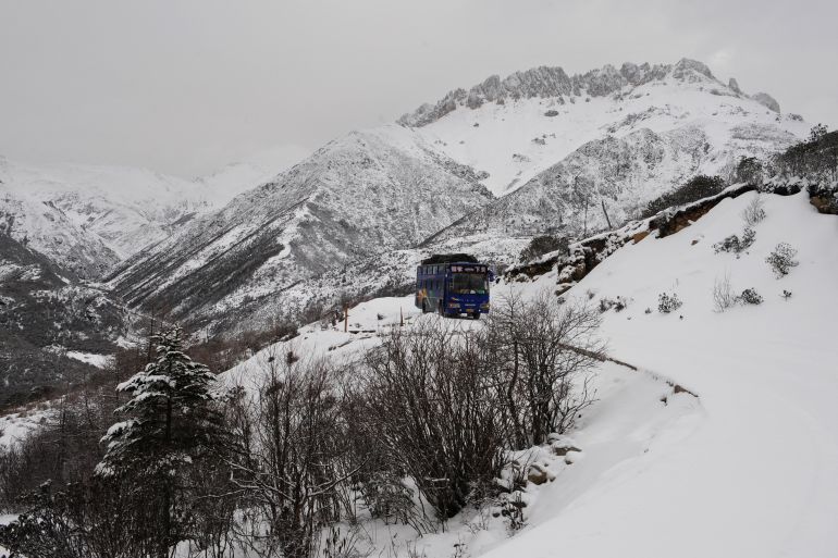 A tour bus makes its way along winding mountain roads on virgin snow leading to the last outpost town of Deqen, north of Shangrila, in the Deqen Tibetan Autonomous Prefecture on March 21, 2008