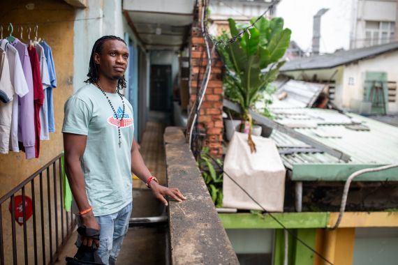 Ezeigwe Evaristus Chukwuebuka standing on a balcony in Ho Chi Minh City. He's wearing a t-shirt and jeans and looks relaxed.