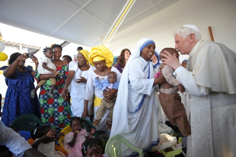 Pope Benedict XVI (R) kisses a child during his visit to foyer "Paix et Joie" at the St. Rita church in Cotonou, during his pastoral visit in Benin November 19, 2011. The pope will be in Benin for 3 days from November 18 to 20. REUTERS/Osservatore Romano/Handout (BENIN - Tags: RELIGION) FOR EDITORIAL USE ONLY. NOT FOR SALE FOR MARKETING OR ADVERTISING CAMPAIGNS. THIS IMAGE HAS BEEN SUPPLIED BY A THIRD PARTY. IT IS DISTRIBUTED, EXACTLY AS RECEIVED BY REUTERS, AS A SERVICE TO CLIENTS