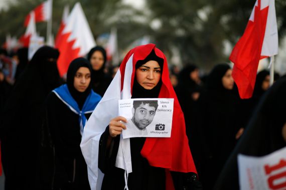 A protester holds a banner during an anti-government rally organized by Bahrain's main opposition party Al Wefaq in Budaiya, west of Manama, December 13, 2013.