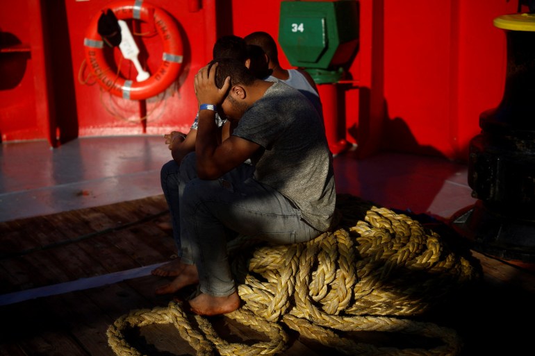 Migrants and refugees rest onboard a rescue boat