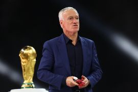 Soccer Football - FIFA World Cup Qatar 2022 - Final - Argentina v France - Lusail Stadium, Lusail, Qatar - December 18, 2022 France coach Didier Deschamps walks past the World Cup trophy after receiving the silver medal REUTERS/Carl Recine