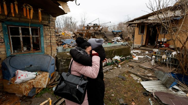 A Kyiv resident embraces a friend as she reacts next to her mother's house damaged during a Russian missile raid in Kyiv, Ukraine.