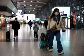 Travellers walk with their luggage at Chengdu Shuangliu International Airport in Chengdu, Sichuan province, China