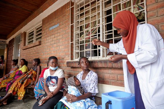 Pilirani Wanja, a clinician at Ndirande Health Centre, demonstrates to clients how to take the cholera vaccine in response to the latest cholera outbreak in Blantyre, Malawi