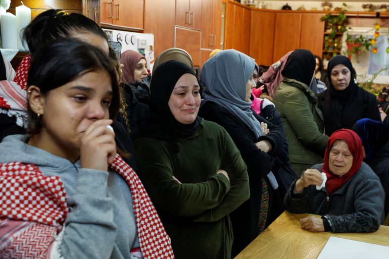 Female mourners look visibly upset at the funeral of Adam Ayyad