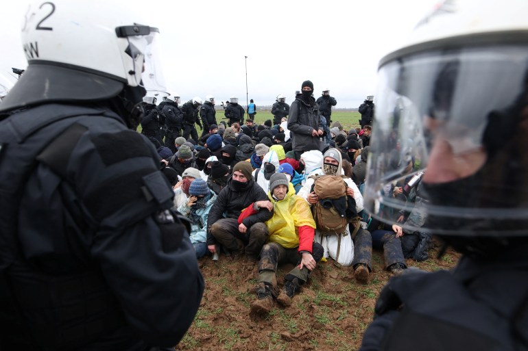 Police officers stop activists who stage a sit-in protest against the expansion of the Garzweiler open-cast lignite mine