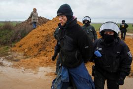 Police officers take away an activist during a sit-in protest against the expansion of the Garzweiler open-cast lignite mine