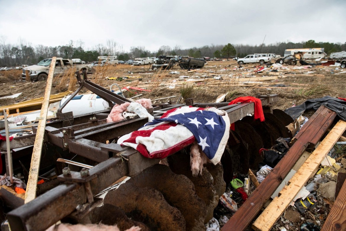An American flag lies in tatters on the rubble after a tornado