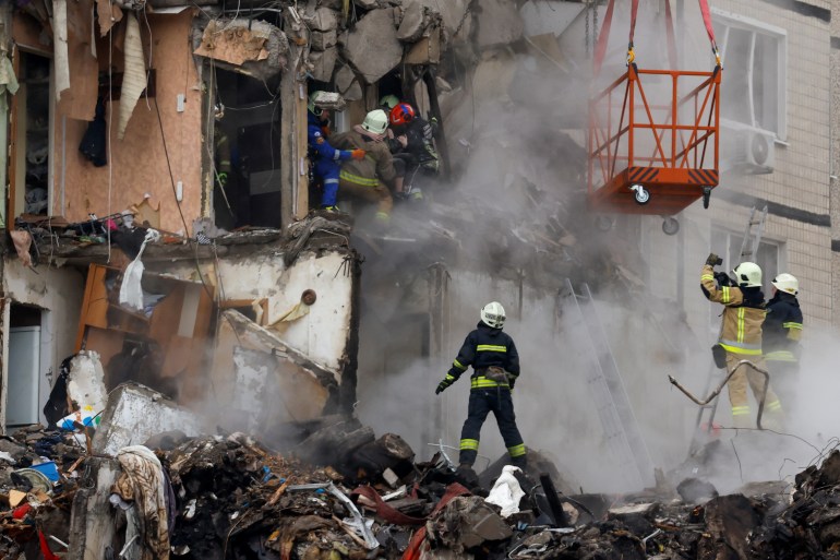 Emergency personnel evacuate a person at the site where an apartment block was heavily damaged by a Russian missile raid in Dnipro, Ukraine.