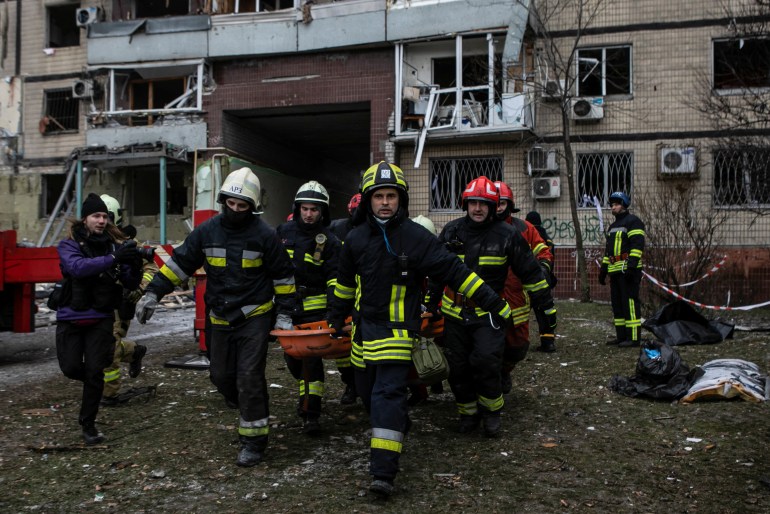 Emergency workers carry a woman released from debris at the site where an apartment block was heavily damaged by a Russian missile strike, amid Russia's attack on Ukraine, in Dnipro, Ukraine January 15, 2023. REUTERS/Yevhenii Zavhorodnii