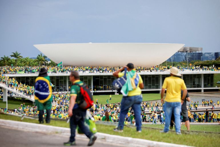 Demonstrators are seen atop government buildings in Brasilia, as well as on the lawn below